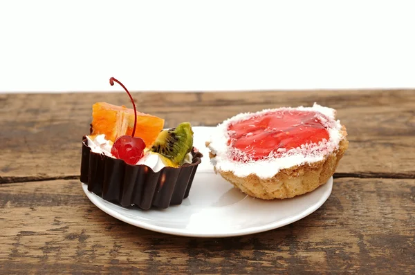 Frisch gebackene Cupcakes auf dunklem Holzgrund — Stockfoto