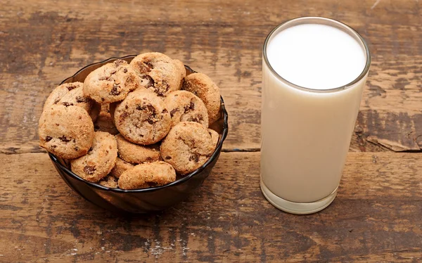 Sklenici mléka a sušenek na dřevěný stůl — Stock fotografie