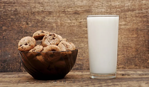 우유와 초콜릿 칩 쿠키 나무 테이블의 유리 — 스톡 사진
