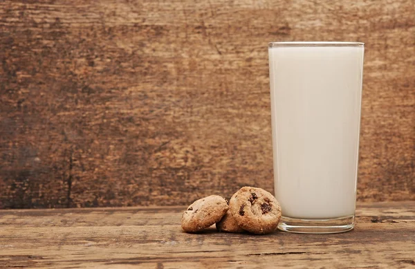 Delicious chocolate cookies staked around glass of fresh milk — Stock Photo, Image