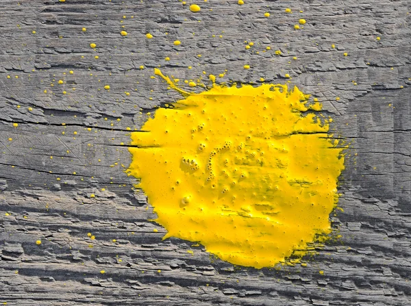 Tinta amarela salpicada sobre o velho fundo de madeira — Fotografia de Stock