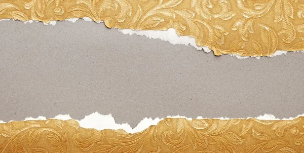 Порванная бумага - золотая бумага, разорванная на части, показывающая нижний слой — стоковое фото