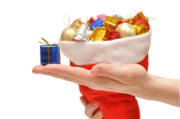 Gift box in hand over Santa Claus hat — Stock Photo, Image