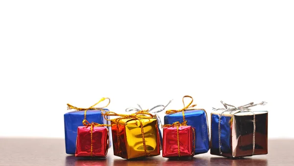 Fechar a caixa de presentes coloridos no fundo de madeira — Fotografia de Stock