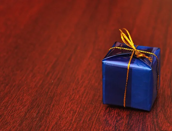 Ahşap zemin üzerinde tek hediye kutusu — Stok fotoğraf