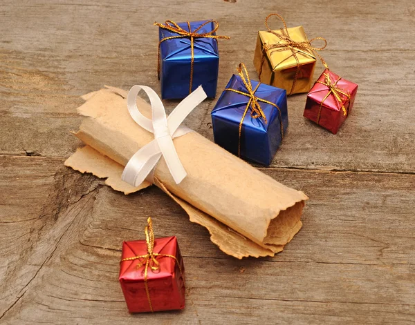 Kleurrijke geschenkdozen met een oude scroll — Stockfoto