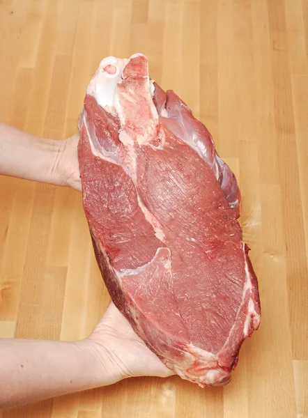 Ein Stück Fleisch in weiblicher Hand — Stockfoto