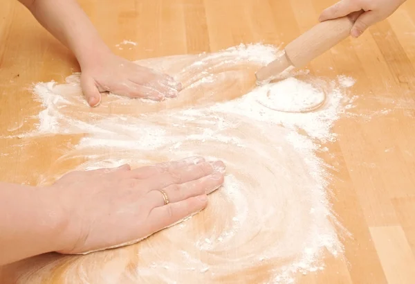 A child is helping mom to knead the dough for baking — Stock Photo, Image