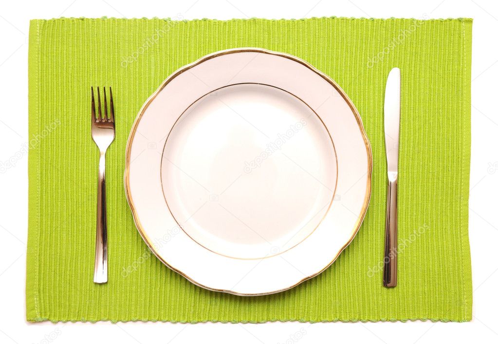 Knife, fork and white plate on a green napkin