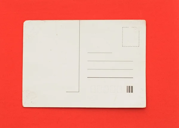 Άδειο παλιά καρτ-ποστάλ σε κόκκινο φόντο — Φωτογραφία Αρχείου
