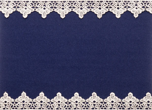 Białe koronki na ciemnym niebieskim tle — Zdjęcie stockowe