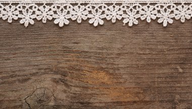 Wooden background with white lace frame