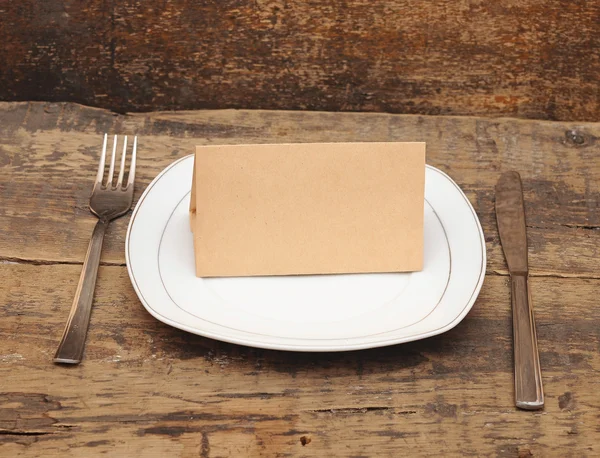 Prato vazio, faca e garfo na mesa de madeira — Fotografia de Stock