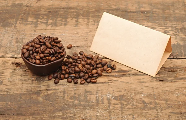 Viejo papel para recetas y granos de café en mesa de madera — Foto de Stock