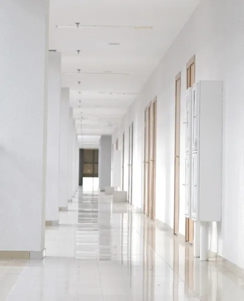 stock image Modern white long corridor with wooden doors on one side