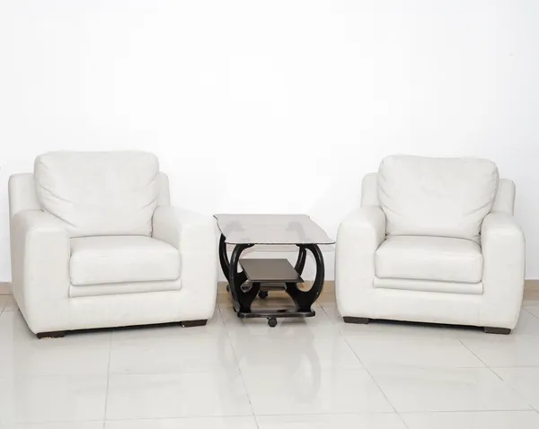 Detail eines modernen Wohnzimmers mit weißem Sessel und Glasscheibe Stockbild