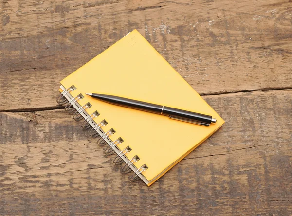 Cuaderno en espiral y pluma en escritorio de madera —  Fotos de Stock