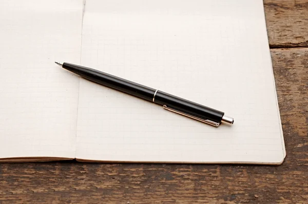 Oude notebook met pen op een houten tafel — Stockfoto