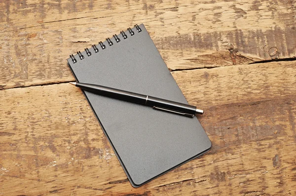 Bloco de notas em branco com caneta na mesa de madeira — Fotografia de Stock