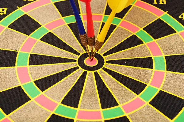 Gesneden beeld van dart doorboord op doel over dartbord — Stockfoto
