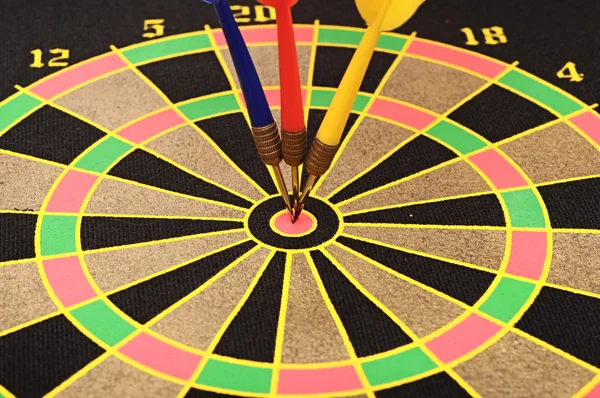 Dartboard with three darts in a bulls eye — Stock Photo, Image