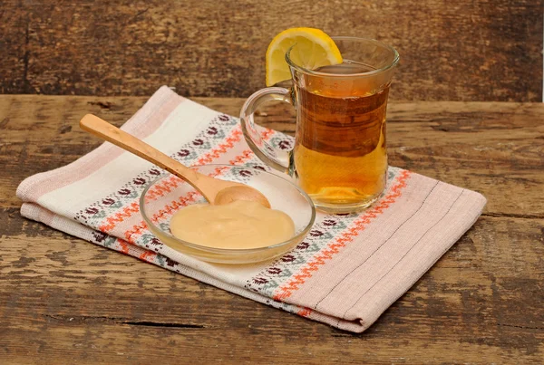 Glas kopje thee met honing op kleurrijke servet — Stockfoto