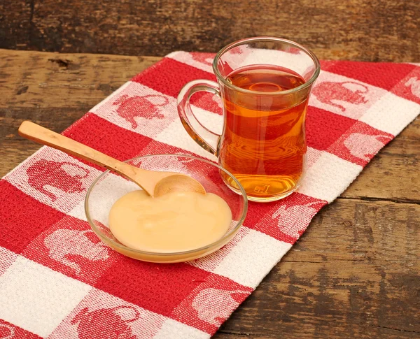 Tasse de thé en verre avec du miel sur une serviette colorée — Photo