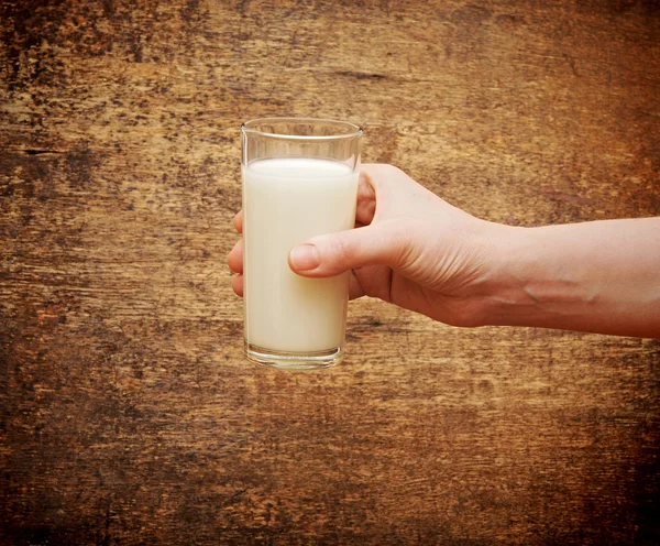 Mão com copo de leite — Fotografia de Stock