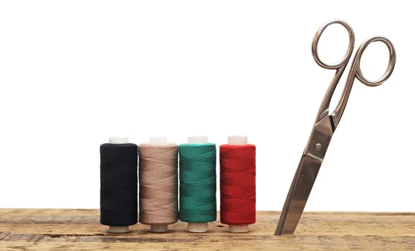 Herramientas para costura hilos de colores y tijeras en bac de madera —  Fotos de Stock