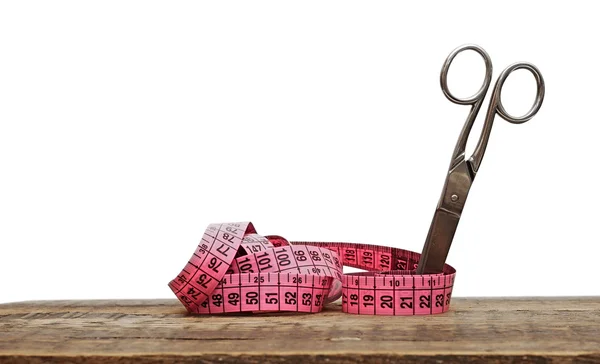 Old scissors and measuring tape on wooden background — Stock Photo, Image
