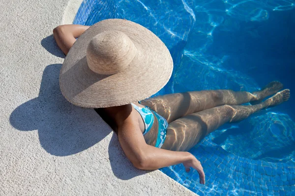 Femme avec chapeau assis dans la piscine — Photo