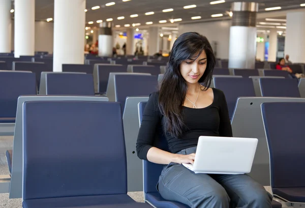 Woman working with her notebook in the airport — Stock Photo, Image