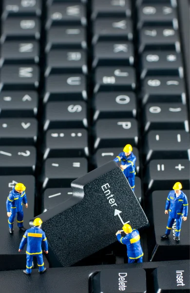 Команда строителей, работающих на компьютерной клавиатуре — стоковое фото