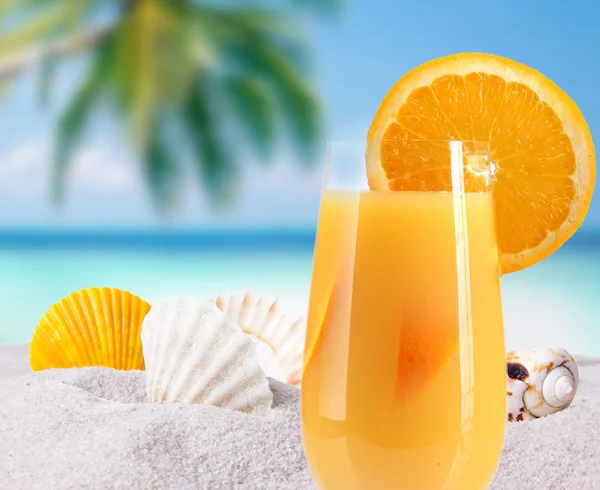 stock image Orange juice in a glass on a table with oranges