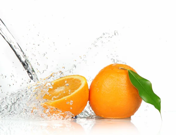 Orangene Früchte und spritzendes Wasser — Stockfoto