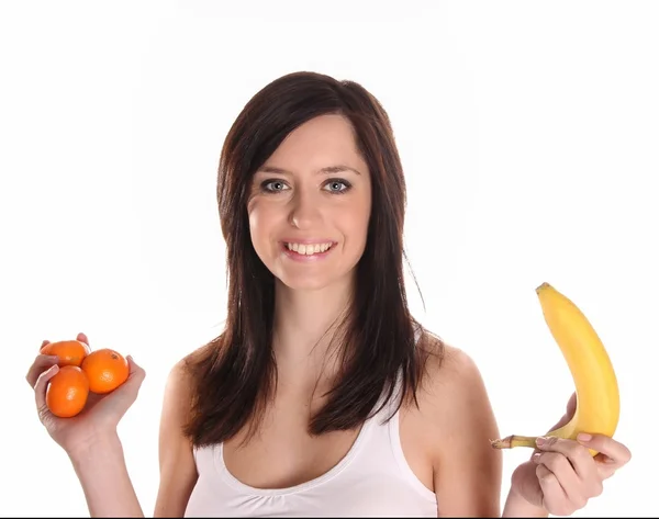 Брюнетка женщина с падающими фруктами на белом — стоковое фото