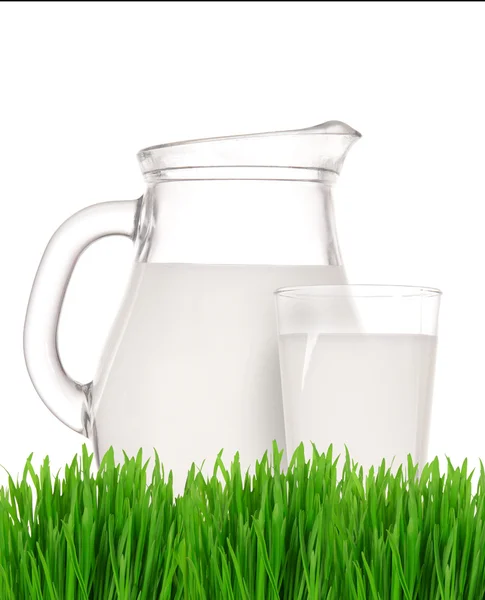 Melkkannetje en glas op het gras — Stockfoto