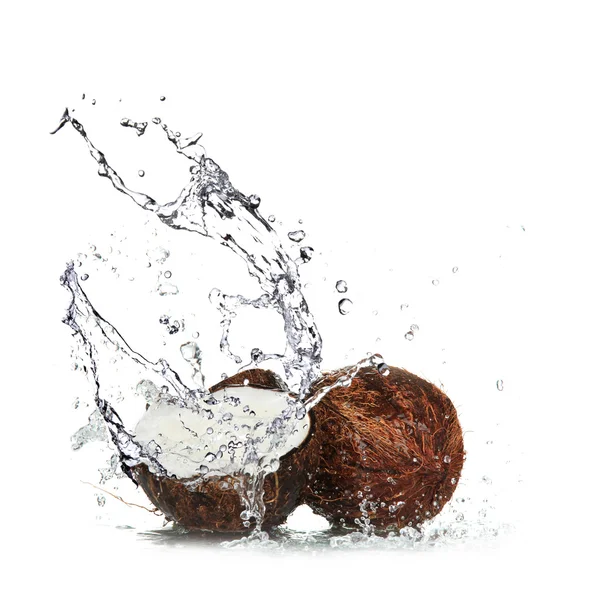 Расколотый кокос с брызгами воды — стоковое фото
