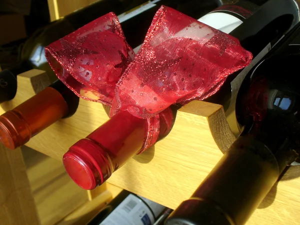 Nastro di Natale rosso su una bottiglia di vino — Foto Stock