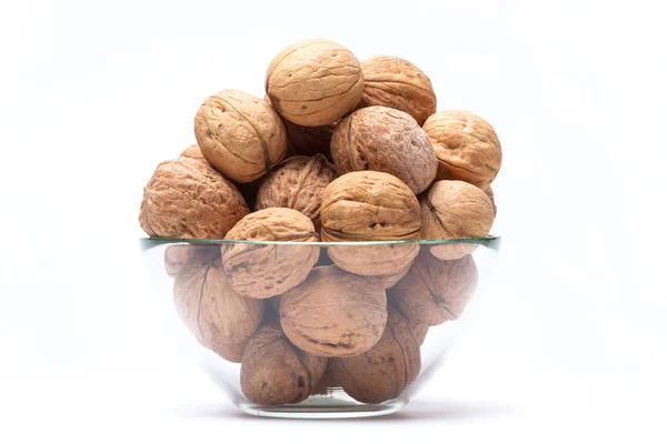 stock image Walnuts lie in a glass bowl isolated on white