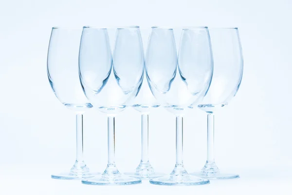 Beyaz kürsüye simetrik olarak boş şarap bardakları — Stok fotoğraf