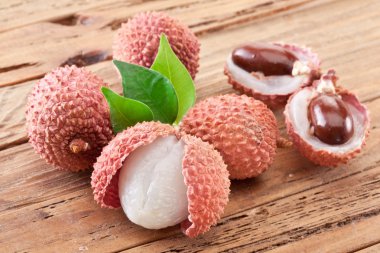 Lychee with leaves on a wooden table. clipart
