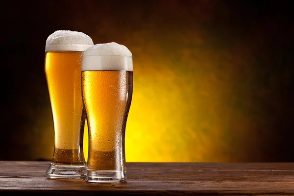 Öl fat med öl glasögon på ett träbord. — Stockfoto