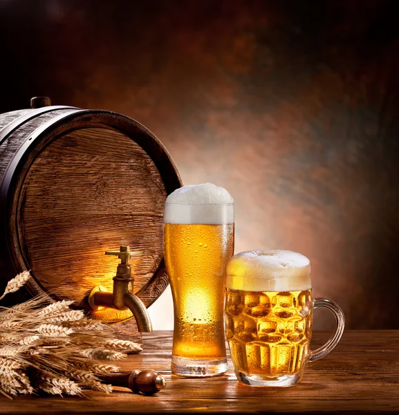 Barril de cerveza con vasos de cerveza en una mesa de madera . Imágenes de stock libres de derechos