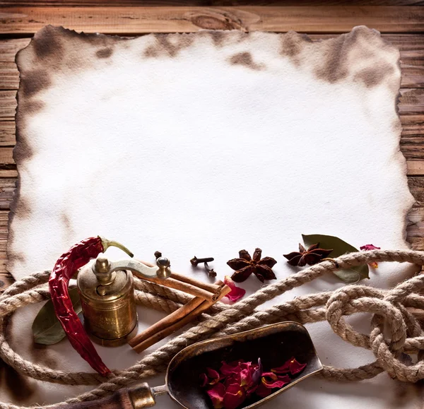 Image of old paper with spices on a wooden surface — Stock Photo, Image