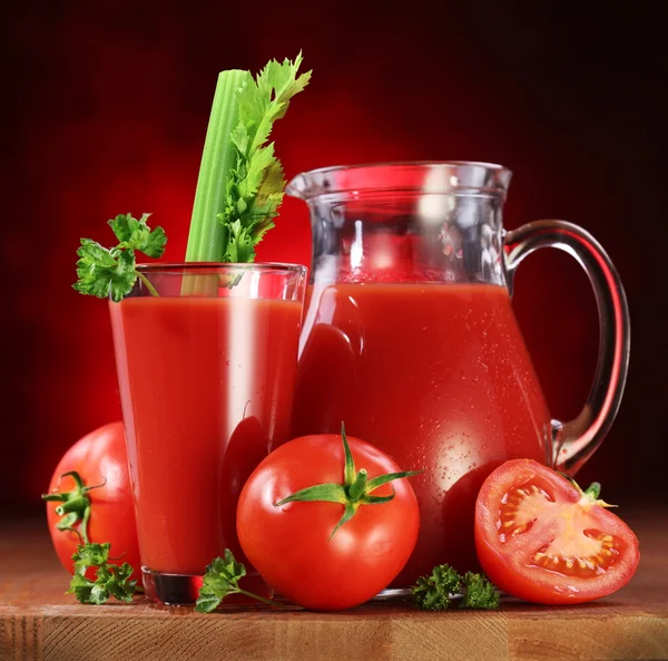 Tomates, jarro e copo cheio de suco de tomate fresco — Fotografia de Stock