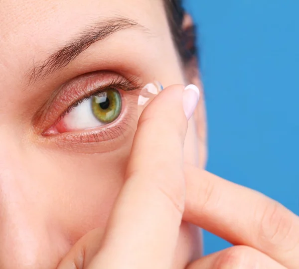 stock image Human eye with corrective lens on a blue background