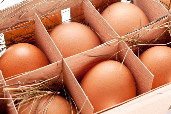 Eggs with a straw in a wooden basket — Stock Photo, Image