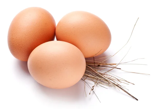 Eier mit Strohhalm auf weißem Hintergrund. — Stockfoto
