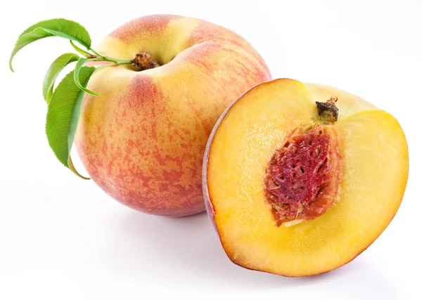 Rijp perzik fruit met bladeren en slises — Stockfoto
